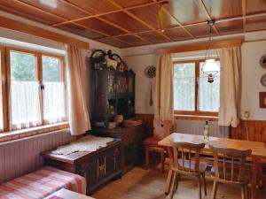 a dining room with a table and a table and chairs at Chata v lese pri rieke Bela in Pribylina