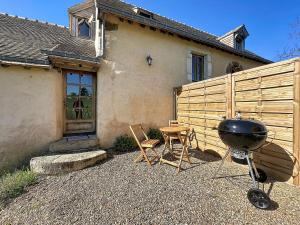 a grill and chairs in front of a house at Charming studio Terrace and parking in Le Mans