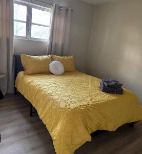 a bedroom with a bed with a yellow comforter and a window at Vintage 2 Bedroom Condo Lake Eola View in Orlando