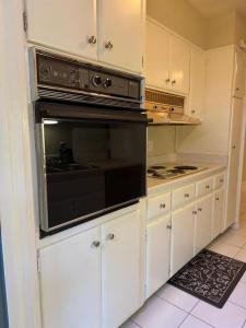 a kitchen with white cabinets and a black oven at Vintage 2 Bedroom Condo Lake Eola View in Orlando