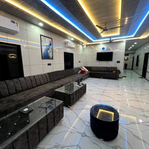 a living room with a couch and a tv at Hotel White Palace in Nāwa