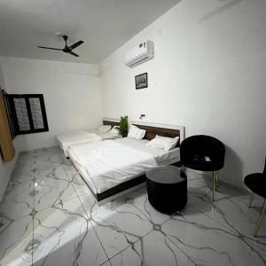 a bedroom with a bed and a ceiling fan at Hotel White Palace in Nāwa