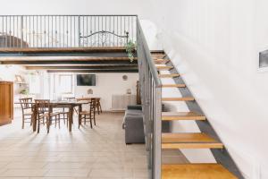 a staircase in a living room with a table and chairs at BHR - Il Nido di Trevi in Trevi +6 photos