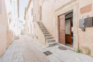 an alley with a staircase in an old building at BHR - Il Nido di Trevi in Trevi