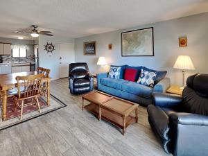 a living room with a blue couch and a table at Lighthouse Point 3B in Tybee Island