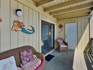 a porch with two chairs and an octopus on the wall at Lighthouse Point 3B in Tybee Island