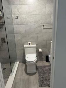 a bathroom with a toilet and a glass shower at Renovated Condo Lake Eola View Great Location in Orlando