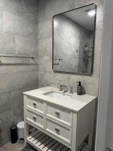 a bathroom with a white sink and a mirror at Renovated Condo Lake Eola View Great Location in Orlando