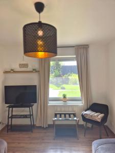 a living room with a large window and a television at Treuberg Rooms - Cuxhaven Northside in Cuxhaven +10 photos