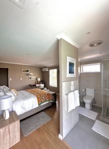 a bedroom with a bed and a sink and a toilet at Wellway Place in Durbanville