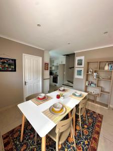 a dining room with a white table and chairs at Wellway Place in Durbanville