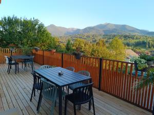 a deck with tables and chairs and mountains in the background at Casa Măriucăi - Ciubar&Mountain View in Borşa