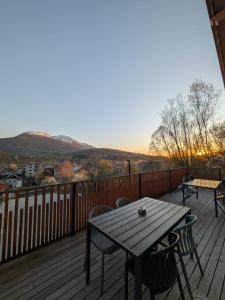 a wooden deck with a table and chairs on it at Casa Măriucăi - Ciubar&Mountain View in Borşa +6 photos