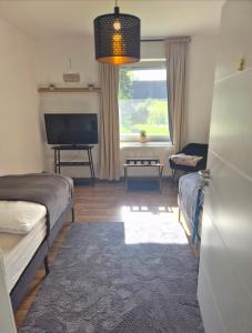 a living room with a bed and a television at Treuberg Rooms - Cuxhaven Northside in Cuxhaven
