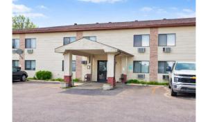 a building with a parking lot in front of it at OYO Hotel Pipestone MN, Canterbury Park in Pipestone
