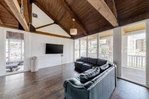 a living room with a leather couch and a tv at Gulf Point Condominiums in South Padre Island