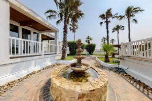 a fountain in front of a house with palm trees at Gulf Point Condominiums in South Padre Island