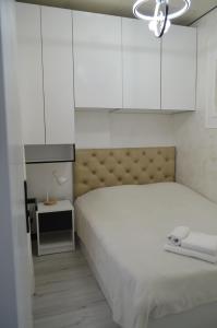 a white bedroom with a bed and white cabinets at PushkinApart in Batumi