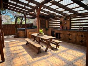 a patio with a table and benches in a kitchen at Jesenická přehrada, u vody in Cheb