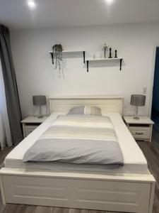 a white bed with two nightstands and two lamps at Hof Sandfort in Bad Laer