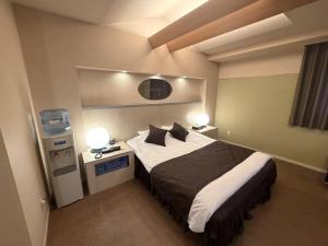 a bedroom with a large bed with two lamps at Hotel Orchid (Adult only) in Kurashiki