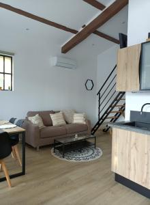 a living room with a couch and a table at Cocooning et Charmante Maisonnette Provençale, avec Extérieurs privatifs et Accès Piscine in Orgon