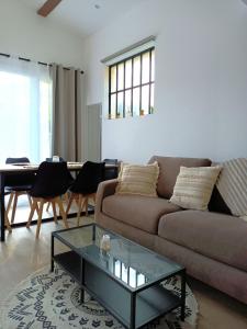 a living room with a couch and a table at Cocooning et Charmante Maisonnette Provençale, avec Extérieurs privatifs et Accès Piscine in Orgon