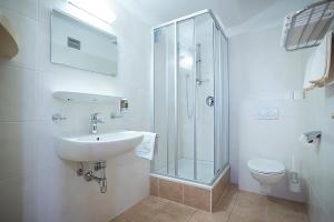 a white bathroom with a sink and a shower at Alpenrelax Krepperhütte in Volders