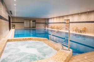 a swimming pool with a jacuzzi tub at Best Western Plus The Connaught Hotel and Spa in Bournemouth