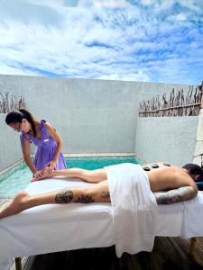 a woman laying on a bed in front of a swimming pool at Pousada Oribá Chalé Boutique Milagres - AL in São Miguel dos Milagres