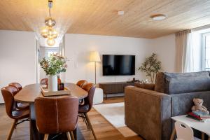 a living room with a table and a couch at Casa Lago in Tüscherz-Alfermée
