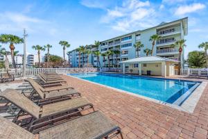 a swimming pool with lounge chairs and a building at Sea Turtle Bungalow - 1136-2 in Siesta Key