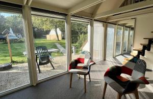 a screened in porch with chairs and a table at Bungalowpark Simpelveld - Alpha 95 in Simpelveld