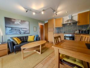 a living room and kitchen with a couch and a table at Culver House Hotel in Port-Eynon