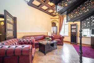 a living room with leather couches and a table at Villa Rosenburg in Thale