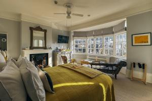 a bedroom with a bed and a living room with a fireplace at The Laindons in Hastings