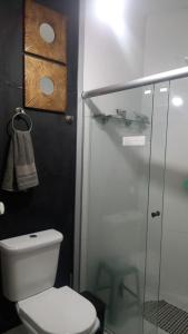a bathroom with a toilet and a glass shower at Suites e Cia - Pousada in Volta Redonda