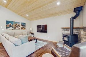 a living room with a white couch and a wood stove at Paintbrush Haven in Ronald