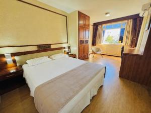 a hotel room with a large bed and a window at Lira Hotel in Curitiba +72 photos