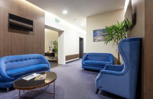 a waiting room with blue chairs and a table at Ribas Rooms Odesa in Odesa