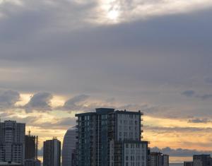 a tall building in a city with a cloudy sky at PushkinApart in Batumi
