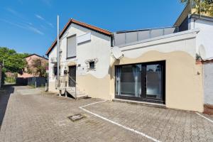 a building with a large glass door on a street at ANDRISS - Travel & Work - 5 BR - Kitchen - Parking in Kaiserslautern