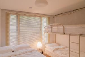 two bunk beds in a room with a window at 메종드브릭 호텔 in Seoul