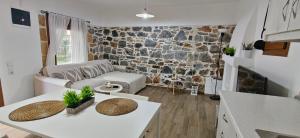 a living room with a table and a stone wall at Antoni's House Makri in Alexandroupoli