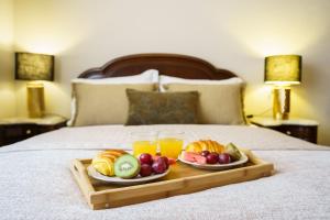 a tray of fruit and drinks on a bed at Casa Betania in Santa Cruz