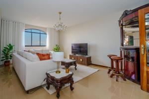 a living room with a white couch and a tv at Casa Betania in Santa Cruz
