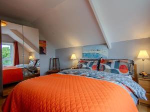 a bedroom with an orange bed with pillows at Culver House Hotel in Port-Eynon