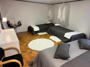 a small room with two beds and a rug at Sandby in Karlholmsbruk