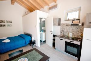 a living room with a blue couch and a kitchen at Malicodia in Santa Maria di Licodia