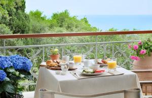 a table with a plate of food on a balcony at Purple Apricot Hotel in Vlachopoulátika